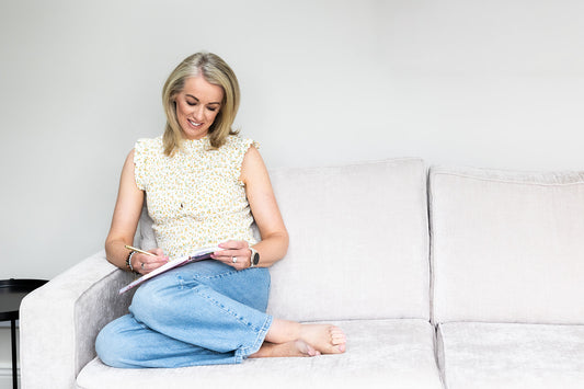 Journal, pen and cup sitting on ottoman